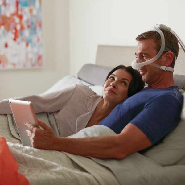 Man using CPAP device in bed