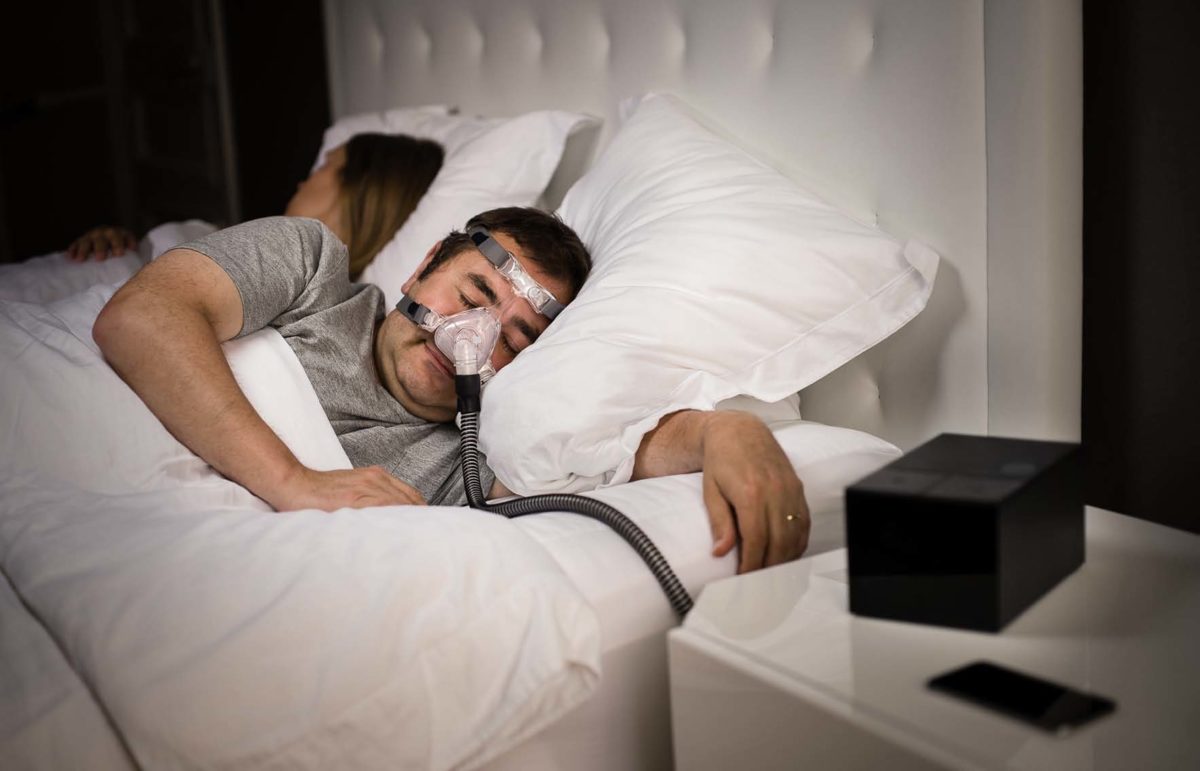 Man with Sleep Apnoea using a CPAP machine with a humidifier