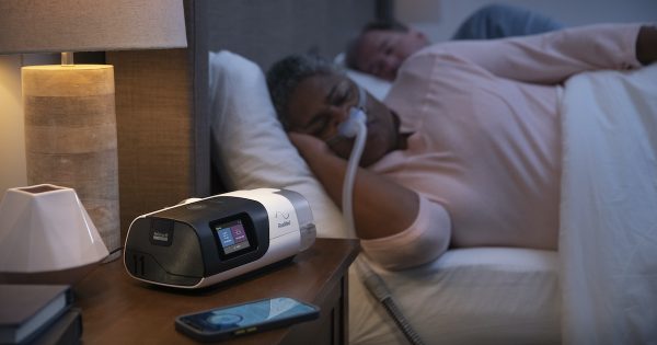Woman in bed using the AirSense 11