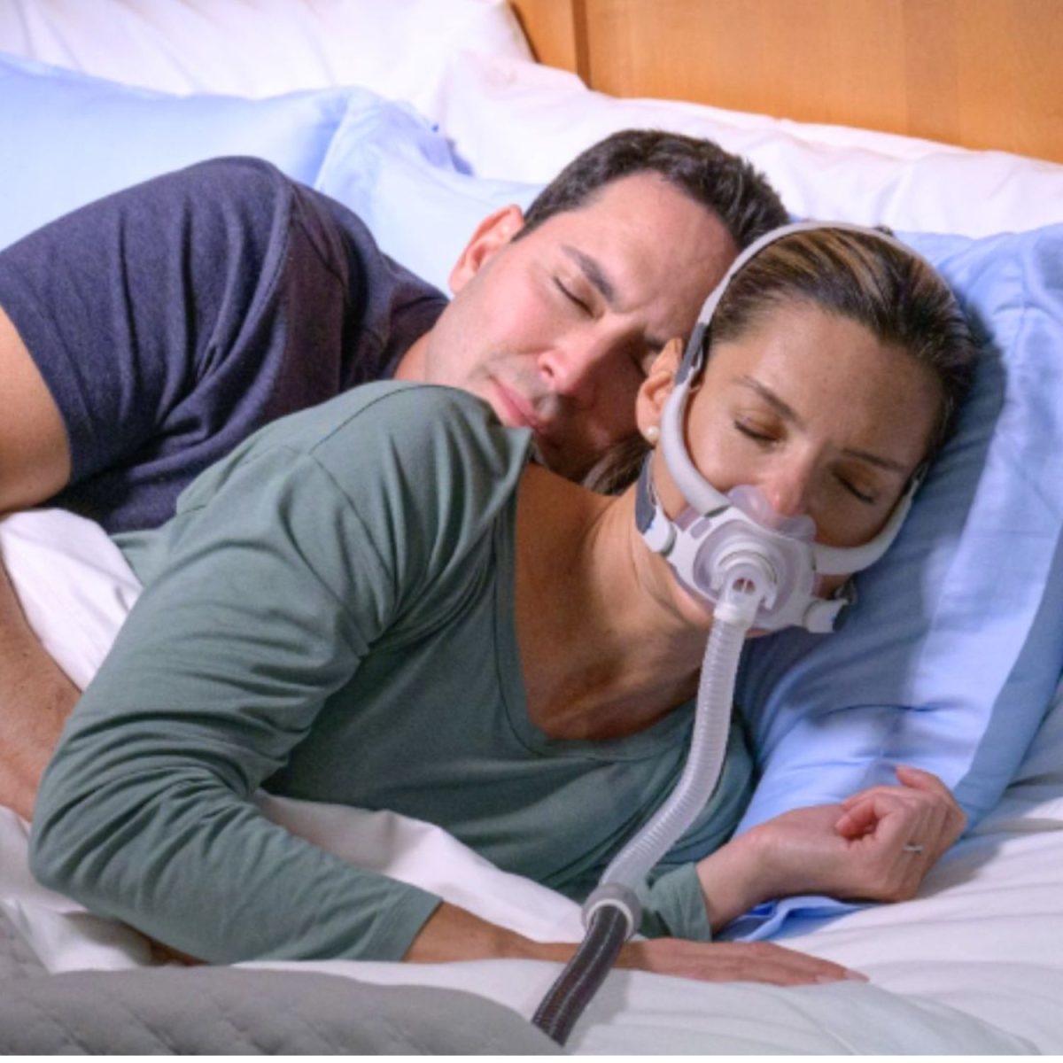 Man and woman laying in bed, woman wearing ResMed AirFit F40 CPAP Mask | Intus Healthcare